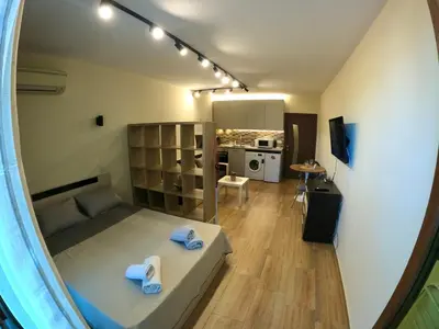 a small room with a bed and a kitchen at Salt Lake Studio in Pomorie