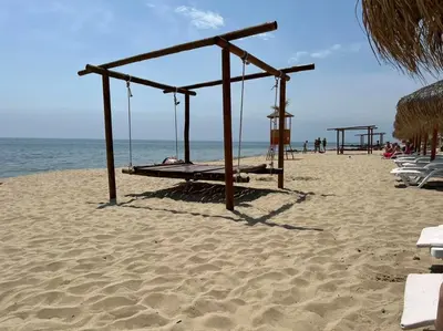 an empty swing set on a sandy beach at Apartmány Bulharsko Sveti Vlas - Garden of Eden in Sveti Vlas