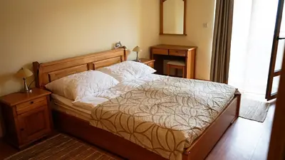 a bedroom with a bed with a wooden head board at Apartmány Bulharsko Sveti Vlas - Garden of Eden in Sveti Vlas