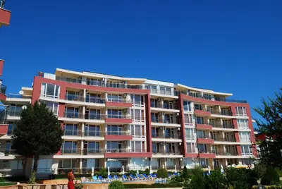a large red building with people standing in front of it at Aurelia Beach Complex in Ravda