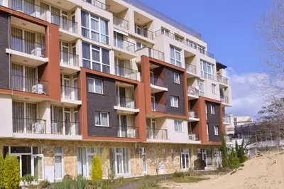 an apartment building with balconies on a beach at Dune Residence Apartments in Sunny Beach