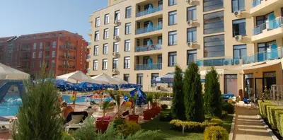 a hotel with a swimming pool in front of a building at Rainbow Luci in Sunny Beach