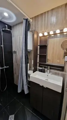 a bathroom with a sink and a shower and a mirror at Varna Hidden Gem in Varna City