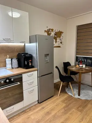 a kitchen with a stainless steel refrigerator and a table at Varna Hidden Gem in Varna City