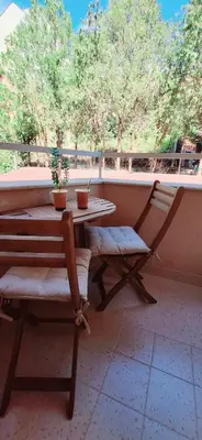 a porch with a table and a bench and a window at Studio M in Sveti Vlas
