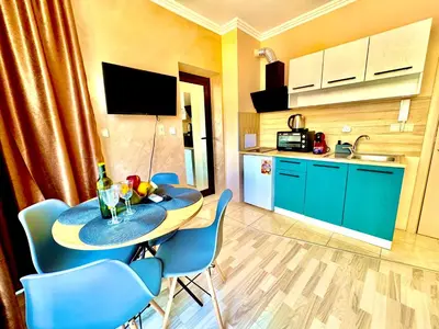 a kitchen and a table and chairs in a room at Sea Sun Holiday Apartments Sunny Beach in Sunny Beach