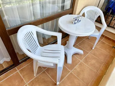 two white chairs and a table on a balcony at Menada Diamant Apartments in Sunny Beach