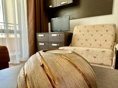 a barrel sitting on a table in a room with a chair at Menada Diamant Apartments in Sunny Beach