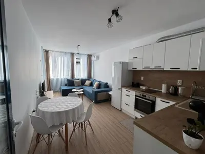 a kitchen and a living room with a table and chairs at Apartment Bela in Burgas City