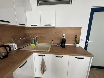 a kitchen with white cabinets and a sink at Apartment Bela in Burgas City