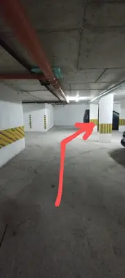 an empty parking garage with a red arrow on the floor at Apartment Bela in Burgas City