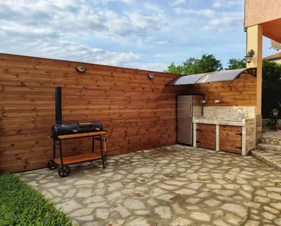 a barbecue grill in front of a wooden fence at Casa Soleada in Bliznatsi
