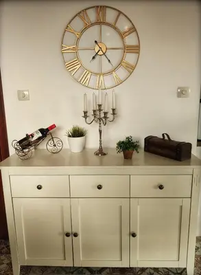 a clock on the wall above a dresser with candles at Casa Soleada in Bliznatsi