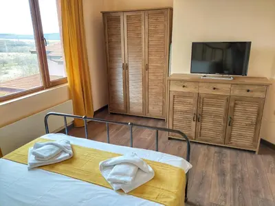 a bedroom with a bed and a tv and a window at Casa Soleada in Bliznatsi