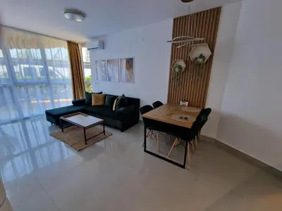 a living room with a couch and a table at Апартамент БАНГЕВИ in Burgas City