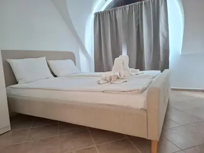 a bed sitting in a room with a window at MAGNOLIA Apartments in Ravda