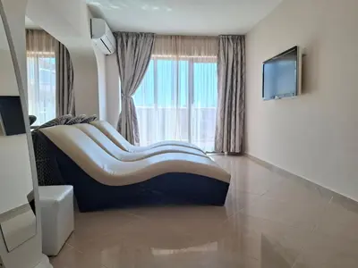 a room with a large couch in front of a window at MAGNOLIA Apartments in Ravda