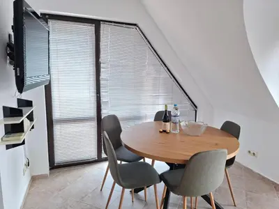 a dining room with a table and chairs and a large window at MAGNOLIA Apartments in Ravda