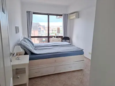 a small bedroom with a bed and a window at MAGNOLIA Apartments in Ravda