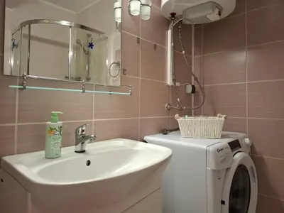 a bathroom with a sink and a washing machine at MAGNOLIA Apartments in Ravda