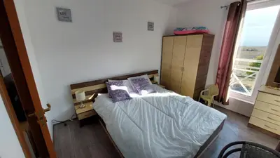 a bedroom with a bed with purple pillows on it at Sunny Day 6 , Sunny beach, 3-Стаен апартамент in Tŭnkovo