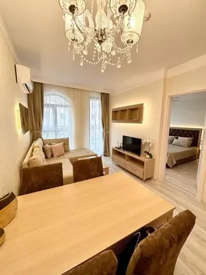 a large room with a bed and a chandelier at VIP Harmony Suites 20 SVETY VLAS in Sveti Vlas