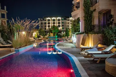 a swimming pool in a resort at night at VIP Harmony Suites 20 SVETY VLAS in Sveti Vlas