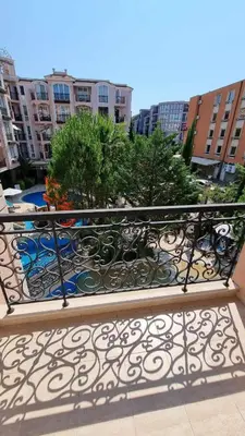 a metal railing on a balcony with trees and buildings at A wonderful vacation home in Sunny Beach
