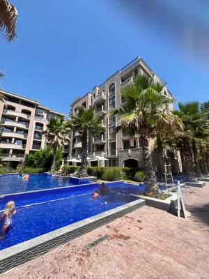 a swimming pool in front of a building with palm trees at Cascadas Family Studio Komfort dla Dwojga lub Rodziny in Sunny Beach