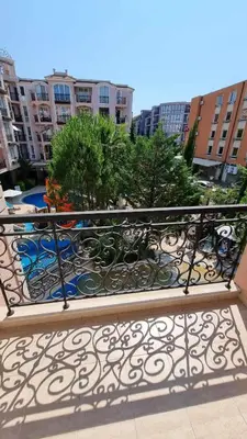 a metal railing on a balcony with trees and buildings at Romans Marin in Sunny Beach