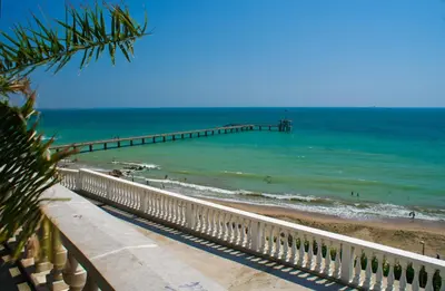 a pier on the beach with people in the water at Apartment Patriarh Evtimiy in Burgas City