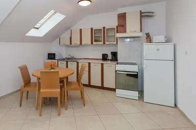 a kitchen with a table and a white refrigerator at Apartment Lermontov in Burgas City
