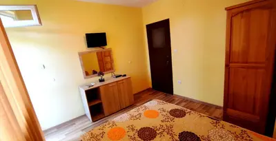 a small bedroom with a bed and a mirror at Апартамент Сиракови Черноморец in Chernomorets