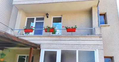 a building with three potted plants on the windows at Апартамент Сиракови Черноморец in Chernomorets