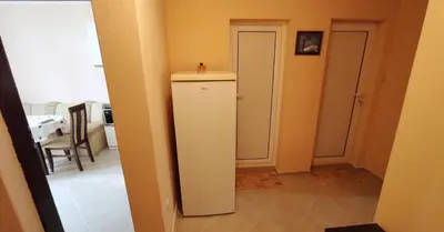 a hallway with a white cabinet and a dining room at Апартамент Сиракови Черноморец in Chernomorets