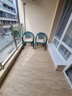 two chairs sitting on the balcony of a house at Apartment Oborishte in Burgas City