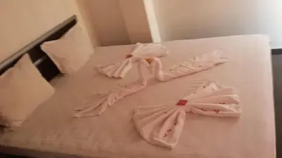 a bed with four white towels on it at Mirage Family Hotel in Primorsko