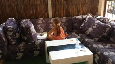 a little girl sitting on a couch at Mirage Family Hotel in Primorsko