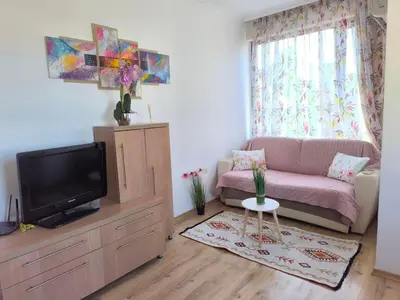 a living room with a couch and a tv at Apartment Rilska - Center and Sea Garden in Burgas City