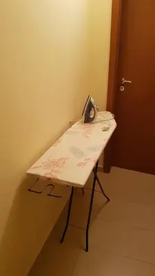 a small table with a clock on it next to a door at Ivanovi Guest House in Primorsko