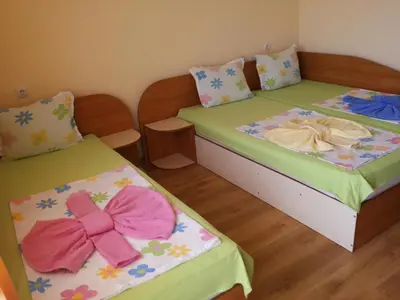 two beds with bows on them in a room at Ivanovi Guest House in Primorsko