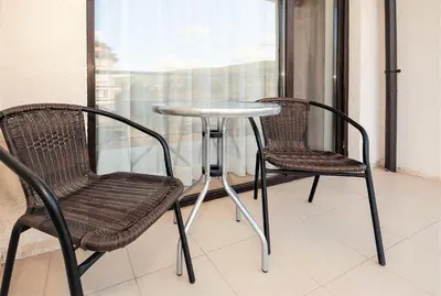 two chairs and a table on a balcony at Seaside 1 BR Apartment with balcony, max 4 Guests in Sunny Beach