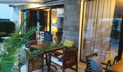 a balcony with a table and chairs on a patio at Seaside 1 BR Apartment with balcony, max 4 Guests in Sunny Beach
