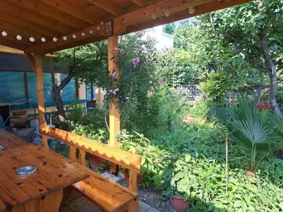 a wooden bench sitting under a wooden pergola at Family Hotel Magnolia - Summer residence in Primorsko
