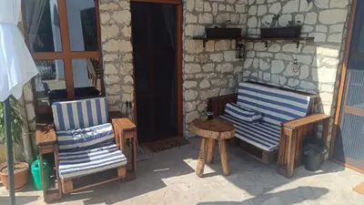 two chairs and a table in front of a building at къщи за гости villa Momino in Avren