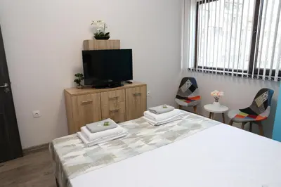 a bedroom with a bed and a flat screen tv at Апартамент за гости Мечта Лазур in Burgas City