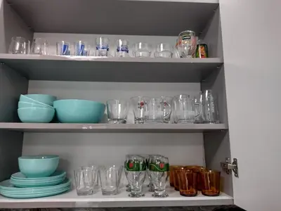 a shelf filled with glasses and bowls and plates at Апартамент за гости Мечта Лазур in Burgas City