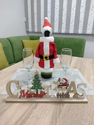 a christmas table with a santa claus on a table with two glasses at Апартамент за гости Мечта Лазур in Burgas City