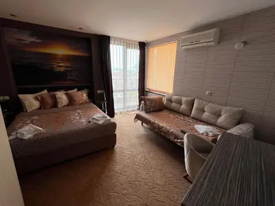 a living room with a couch and a couch and a bed at Hotel Lazur in Kiten