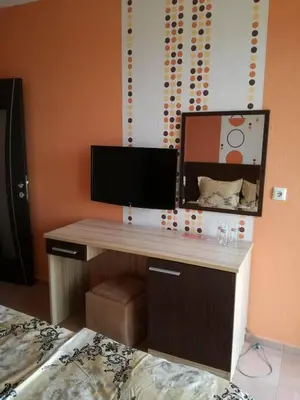 a desk in a room with a bed and a mirror at Hotel Lazur in Kiten